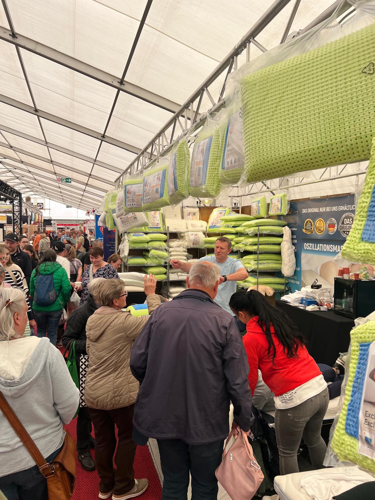 Blick ueber den Messestand mit Regalen voller Schlafzauber-Kissen